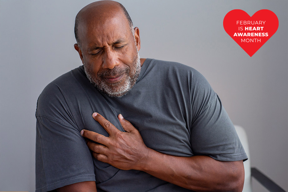 Man grimacing while holding chest