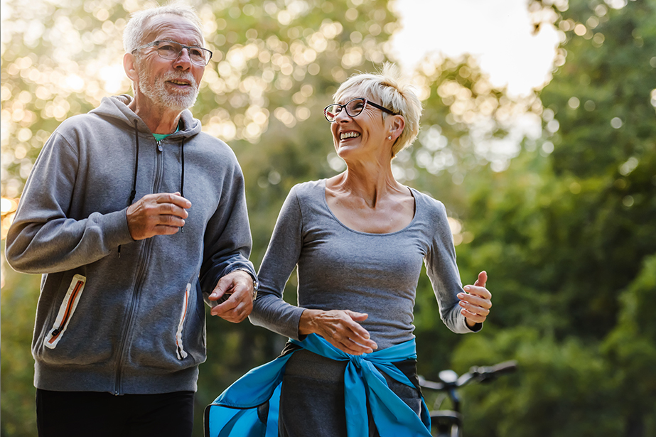 An elderly couple working out smiling. 