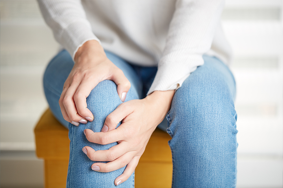 Woman holding her knee in pain.