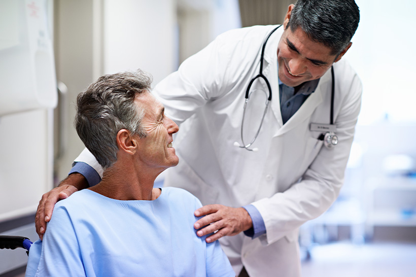 doctor offers comfort to man seated in a wheelchair