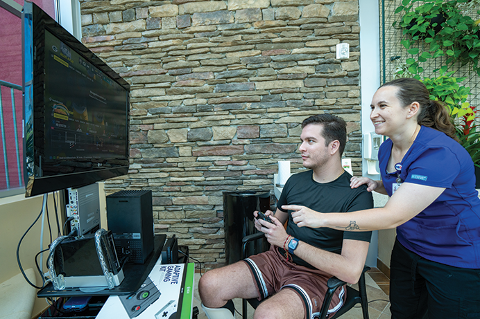 rehab patient and PT playing adaptive game